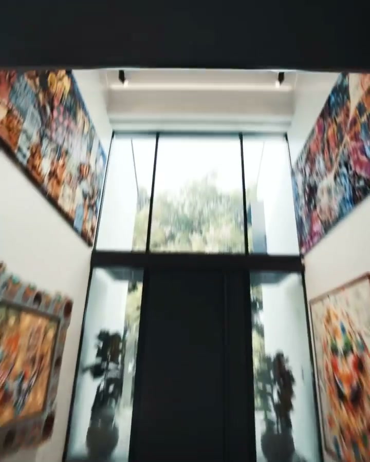 The double-height art void, hung with colour, glazed to the garden